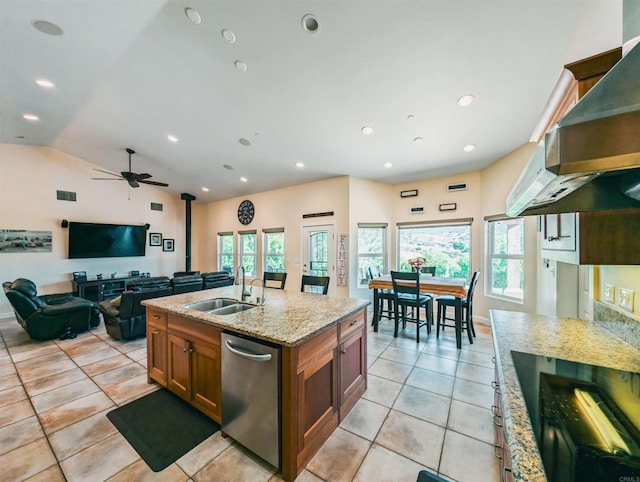 kitchen featuring sink, dishwasher, light stone counters, a healthy amount of sunlight, and wall chimney exhaust hood