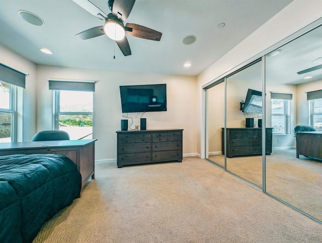 carpeted bedroom with multiple windows, ceiling fan, and a closet