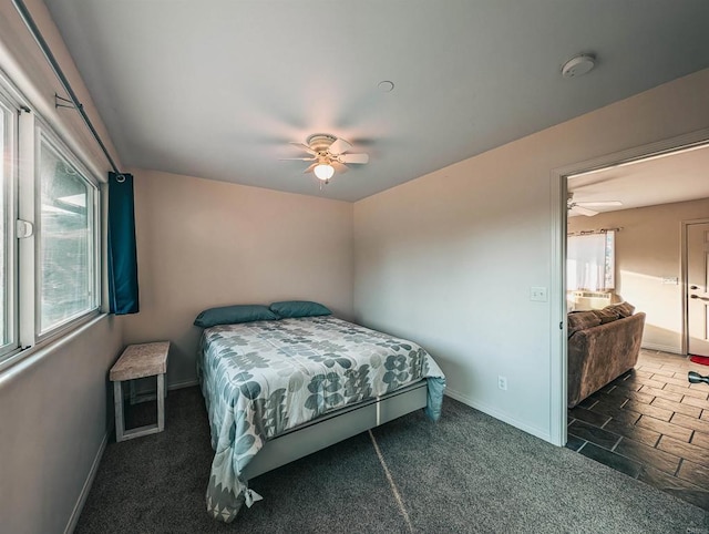 bedroom with ceiling fan and dark colored carpet