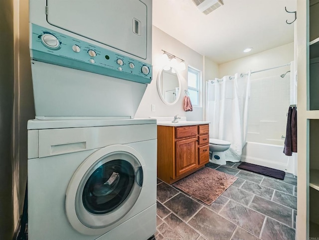 laundry area featuring stacked washer and clothes dryer and sink