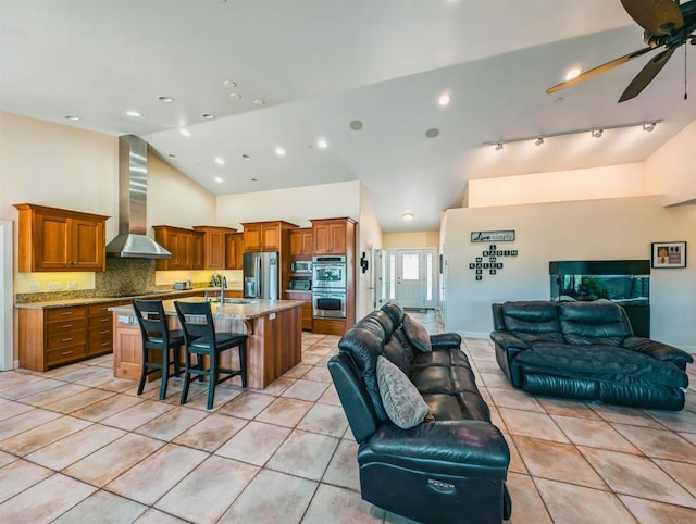 tiled living room with ceiling fan, high vaulted ceiling, and sink