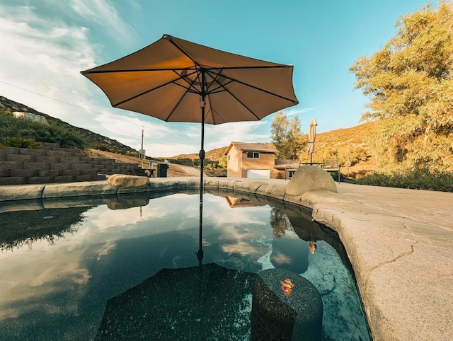 view of pool featuring area for grilling and a mountain view