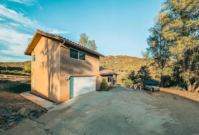 view of property exterior featuring a mountain view and a garage