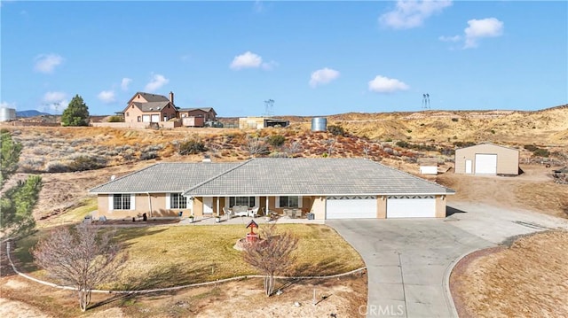 ranch-style house with a garage, driveway, a tiled roof, and a front lawn