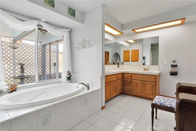 bathroom with tile patterned floors, vanity, and a bath