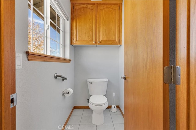 bathroom with tile patterned flooring, baseboards, and toilet