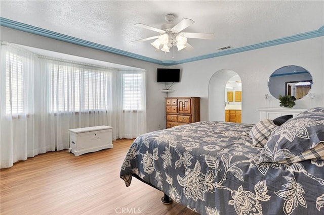 bedroom featuring arched walkways, visible vents, multiple windows, and wood finished floors