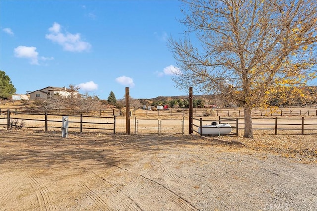 view of yard featuring fence, an enclosed area, and a rural view