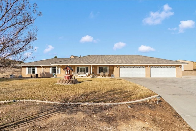 ranch-style home featuring concrete driveway, stucco siding, a tiled roof, an attached garage, and a front yard