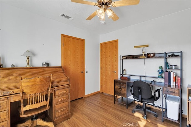 office with baseboards, ceiling fan, visible vents, and wood finished floors