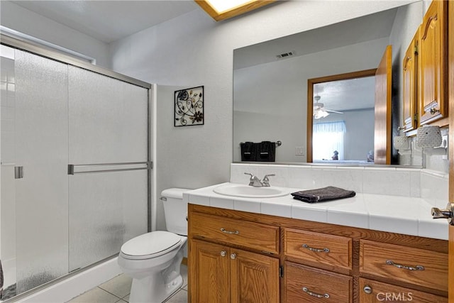 full bathroom featuring a stall shower, vanity, toilet, and tile patterned floors