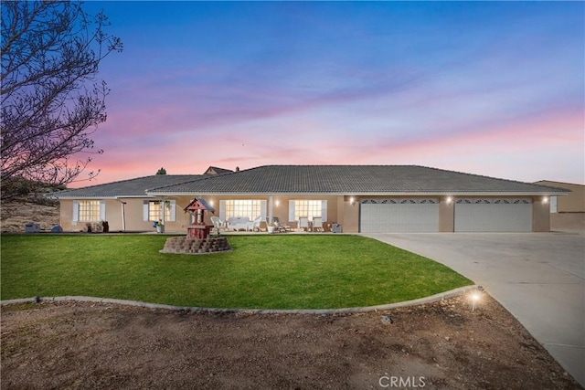 single story home featuring a garage and a yard