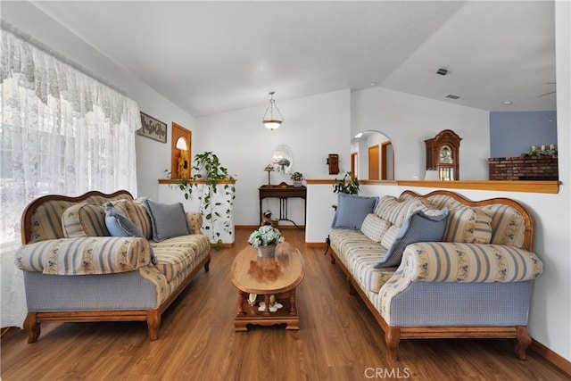 living room with vaulted ceiling, wood finished floors, and visible vents