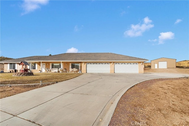 single story home with a garage, covered porch, driveway, and stucco siding