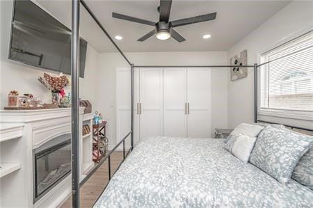 bedroom with ceiling fan, a closet, and wood-type flooring