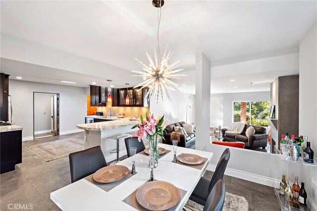 dining space with sink and a chandelier