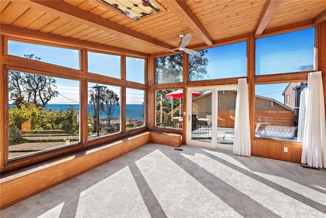 unfurnished sunroom with ceiling fan, wood ceiling, beamed ceiling, and a water view