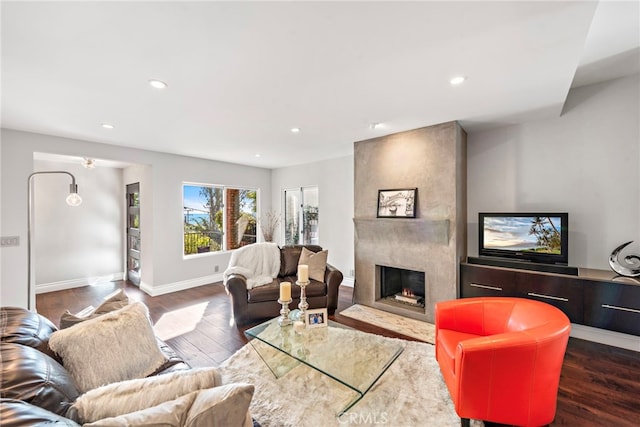 living room with dark hardwood / wood-style flooring and a fireplace