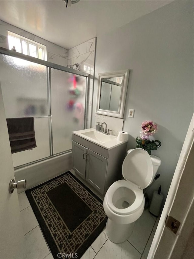 full bathroom with toilet, bath / shower combo with glass door, tile patterned floors, and vanity