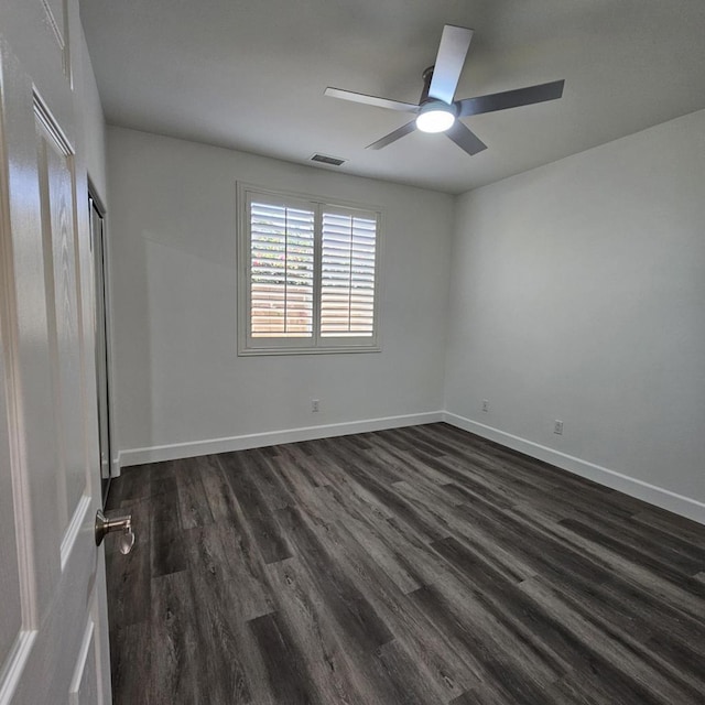 spare room featuring ceiling fan and dark wood-type flooring