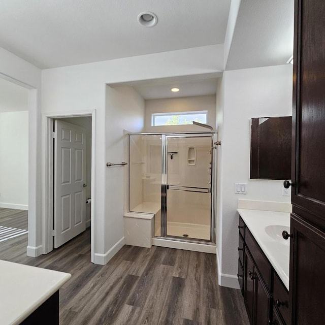 bathroom with wood-type flooring, walk in shower, and vanity