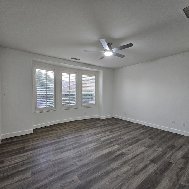 unfurnished room with dark wood-type flooring, plenty of natural light, and ceiling fan