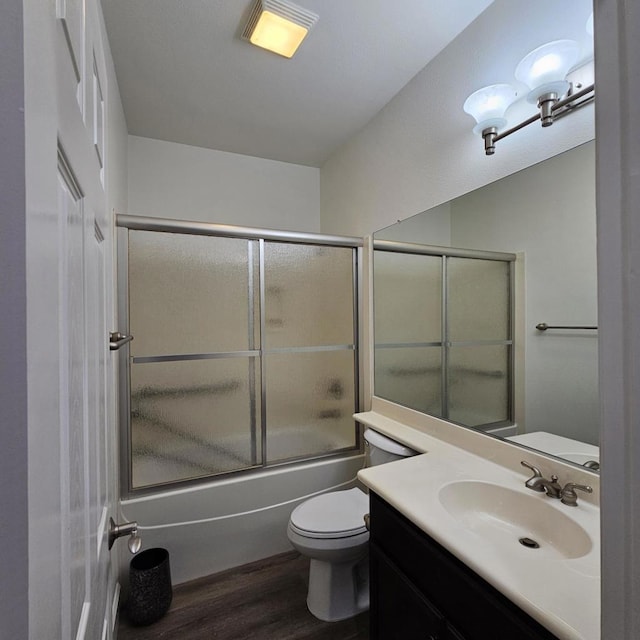 full bathroom featuring toilet, wood-type flooring, vanity, and shower / bath combination with glass door