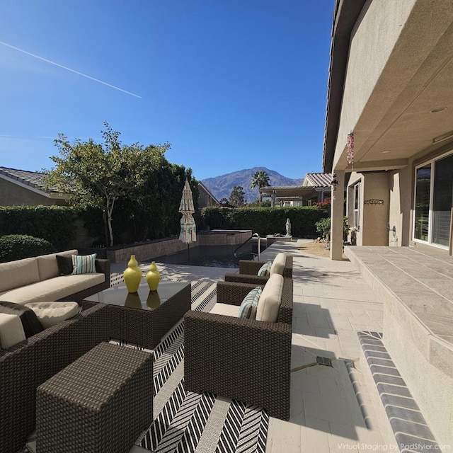 view of patio / terrace with an outdoor living space and a mountain view