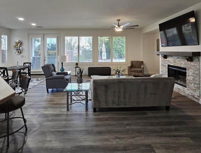 living room with ceiling fan, a fireplace, and dark wood-type flooring