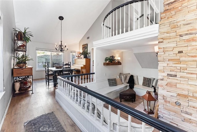 interior space featuring high vaulted ceiling, hardwood / wood-style floors, and a chandelier