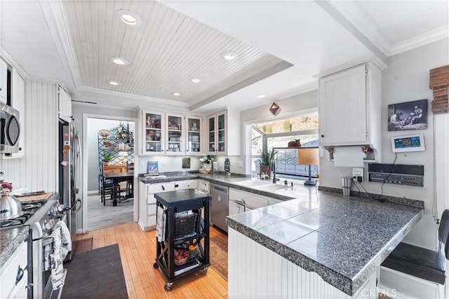 kitchen with kitchen peninsula, appliances with stainless steel finishes, wood ceiling, and white cabinetry