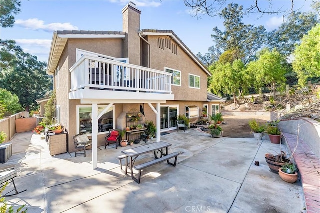 rear view of house with a patio area and a balcony