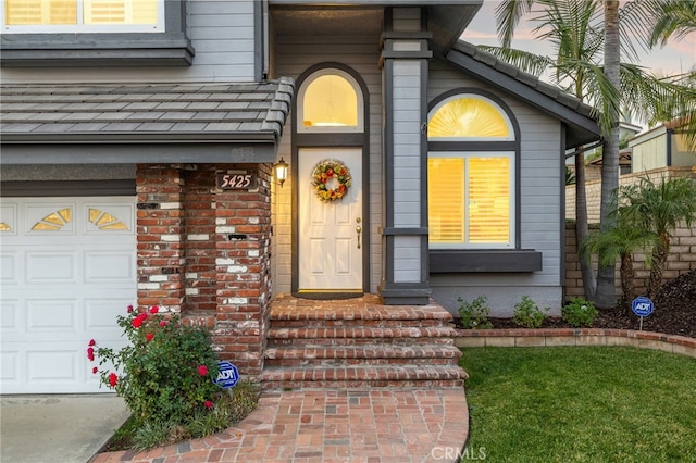 exterior entry at dusk featuring a garage