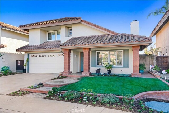 mediterranean / spanish home with a front lawn and a garage