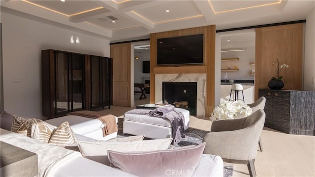 living room with sink, a high end fireplace, beamed ceiling, and coffered ceiling