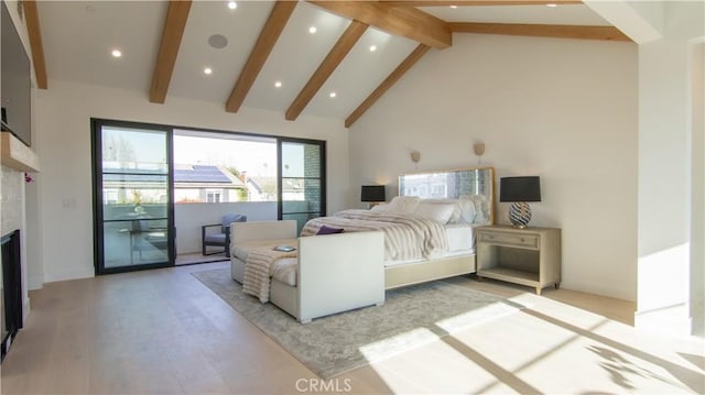 bedroom featuring light hardwood / wood-style floors, access to exterior, high vaulted ceiling, a tile fireplace, and beamed ceiling