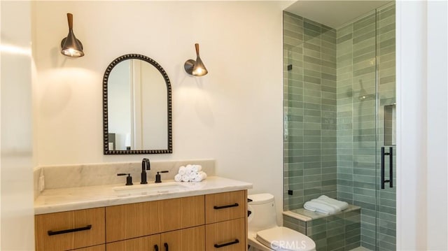 bathroom with toilet, vanity, and a shower with door