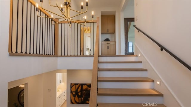 stairs featuring an inviting chandelier