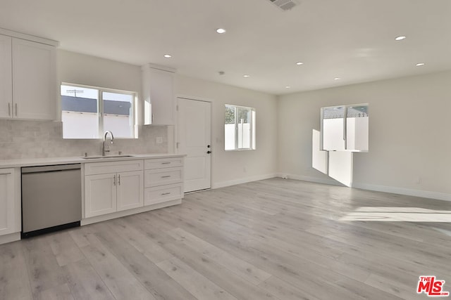 kitchen featuring stainless steel dishwasher, white cabinets, and sink