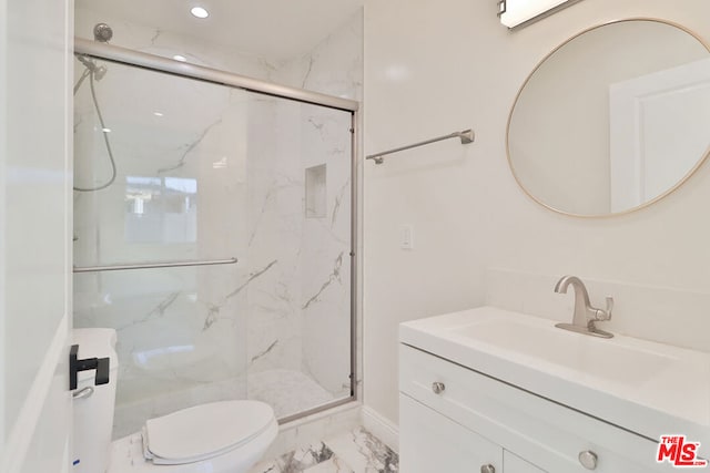 bathroom with toilet, vanity, and a shower with door