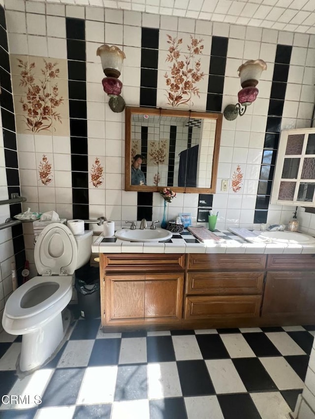 bathroom featuring tile walls, toilet, and vanity