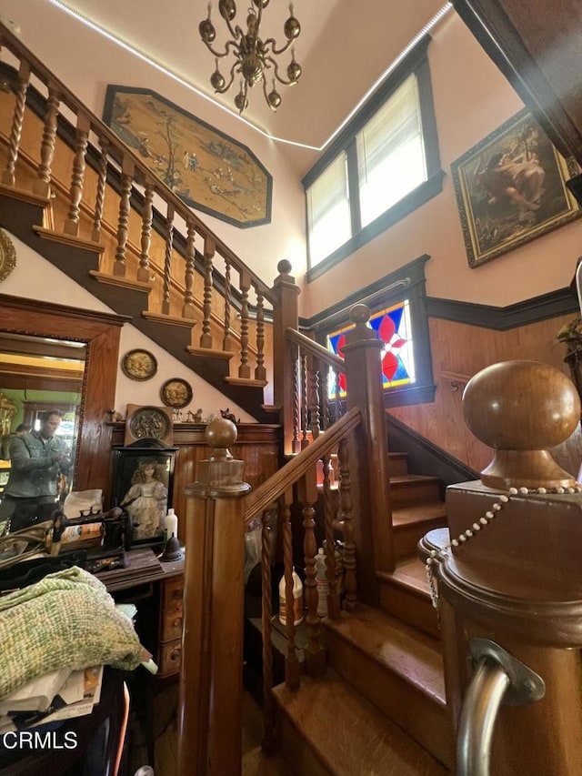 stairs with a towering ceiling and wooden walls