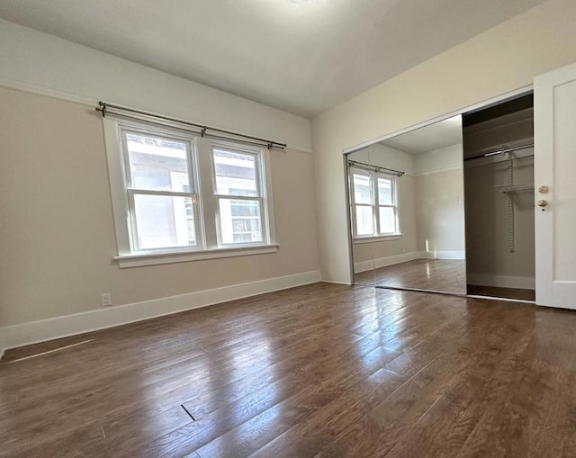 unfurnished bedroom with dark hardwood / wood-style flooring and a closet