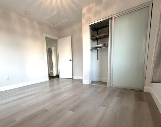 unfurnished bedroom featuring light wood-type flooring and a closet