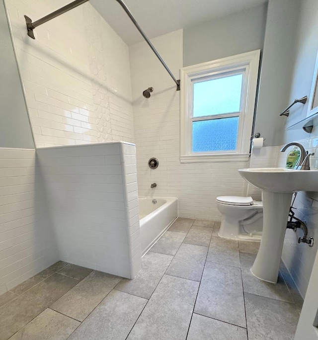 bathroom featuring toilet and tiled shower / bath combo