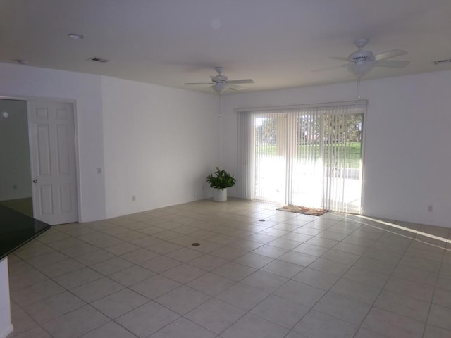 empty room with ceiling fan and light tile patterned floors