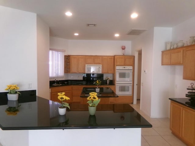 kitchen featuring kitchen peninsula, sink, white appliances, and light tile patterned flooring