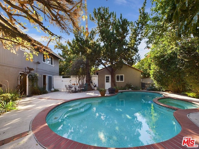 view of pool with a patio area and an in ground hot tub