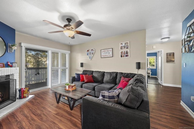 living room with ceiling fan, dark hardwood / wood-style floors, and a fireplace