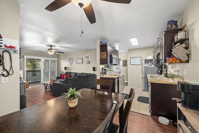 dining room with ceiling fan, a textured ceiling, and dark hardwood / wood-style floors